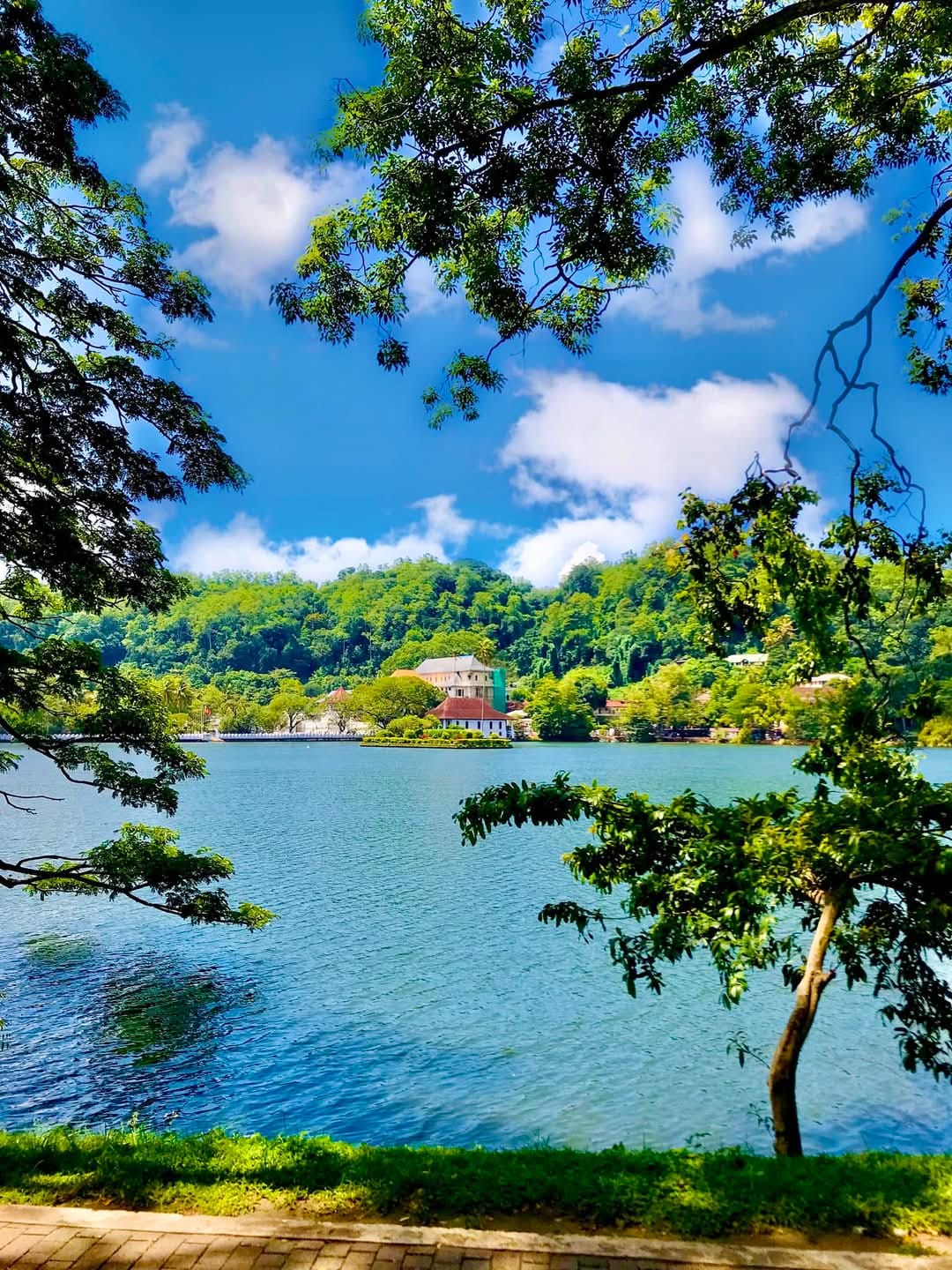 View across Kandy Lake toward the Temple of the Sacred Tooth Relic on a sunny day